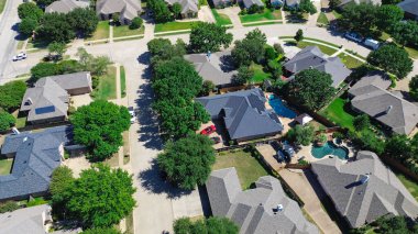 Kuzey Richland Hills, Teksas 'taki banliyö evinin güneş paneli çatısı. Etrafı olgun ağaçlar ve manzaralı bahçelerle çevrili. Sıfır emisyon enerjisinin ve sürdürülebilir yeşil yaşamın görsel göstergesi. ABD