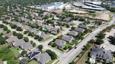 Kuzey Richland Hills, Teksas 'taki banliyö yerleşim yeri yeşil çimenli, arka bahçe havuzlu iki katlı evler gösteriyor. Arka planda hafif endüstriyel binalar, lojistik merkezler depolama