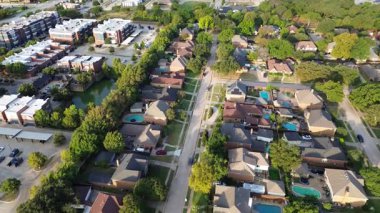 Havuzu, havuzu, parkı, olgun ağaçlarla çevrili modern beyaz çatılı apartman kompleksi, arka bahçeli lüks evler, Denton County, Teksas 'ta entegre konut yoğunluğu