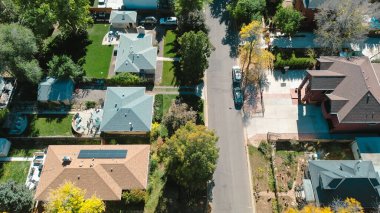 Denver banliyöleri, güneş panelleri çatısı altın ağaç tepe örtüsüyle çevrili bir ev. Bahçe bahçeleri, ağaçlarla kaplı caddeler ve bal çekirgelerinden gelen filtrelenmiş ışık, akçaağaçlar. ABD