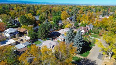 South Park Hill, Denver banliyösü yoğun sonbahar yeşillikleriyle çevrili çatının ortasındaki evi gösteriyor. Sarı ve turuncu taç çerçeveli çatılar, sessiz sokaklar ve berrak gökyüzünün altındaki dağ manzarası. ABD