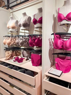 GRAPEVINE, TEXAS-OCT 21, 2025: Victoria Secret mağazasında sadece sütyen mankeni, mor, kırmızı, bej renkte, uyumlu külot, spot ışık bölgesi düzeninde çekmeceler düzenlenmiş. ABD