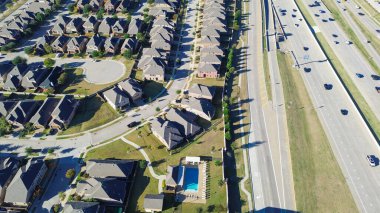 Castle Hills, Lewisville TX, 121. Otoyol 'un yanındaki kıvrımlı sokağın olduğu iki katlı yeni gelişim evleri gösteriyor. Yoğun konut şebekesi yoğun otoyol ve otoyol trafiğiyle çelişiyor. ABD