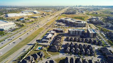 Plano şehir merkezi, Castle Hills yerleşim evleri, apartmanlar ve 121. Otoyol 'un silueti. Depolar, iş parkı yan yolları, bölgesel büyüme ve imar çeşitliliği. ABD