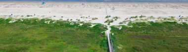 Panorama hava manzaralı yükseltilmiş tahta kaldırım, Galveston, Teksas 'taki Güney Sahili yakınlarındaki sık kıyı bitkilerinden geçer. ADA' ya uyumlu kumlu sahil şeridi erişimi kırılgan kum ekosistemlerini korur. ABD