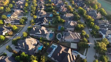 Teksas, Lantana 'da dolambaçlı yollar boyunca yayılan evler, yoğun ağaç örtüsüyle çevrili. Havuzlar, garaj yolları, temiz kaldırımlar banliyö planlamasını ve golf sahasının yakınındaki varlıklı konağı yansıtıyor.