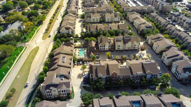 Büyük apartman kompleksindeki yoğun birimler Dallas Fort Worth 'un varoşlarında, kahverengi çatıları, otoparkları, garaj yolları, halk havuzları, avluları olan yerleşim yerlerini gösteren yapılandırılmış yerleşim yerleri. ABD