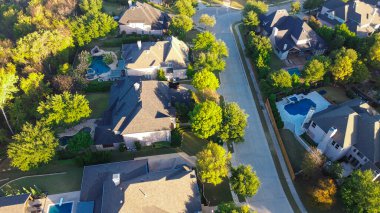 Ağaçlarla kaplı caddeleri, arka bahçeli havuzları ve sıcak ışıkta uzun gölgeler ve Texas 'ta mimari birlikle yakalanan ağaçlık tamponları olan Lantana mahallesine yakın çekim. ABD