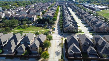 Otoparkları olan çok katlı daireler Central Park 'ın yanında ve sıra sıra tek aile evlerinin yanında, kanalın yanında, katmanlı yerleşim bölgelerinin, Çiçek Tepesi, Teksas' ta arazi kullanımı çeşitliliğinin resmedildiği. ABD