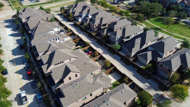 Çatı katlı evler kaldırımları ve ağaçları olan dikey caddeler, yürüyüş yolları ve dağınık ağaçları olan bir parka bitişik, Texas, Çiçek Tepesi 'ndeki büyük çok katlı apartman kompleksi. ABD