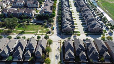 Evlerin yanında yaya köprüsü olan bir kanal, çok katlı apartman kompleksi, daha geniş yollarla çevrili, yeşil yürüyüş yolları olan bir alan, tutarlı aralıklar, görsel ritim, çiçek tepeciği, TX. ABD