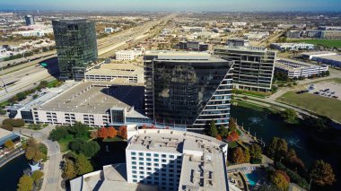 Modern çok katlı otopark çatısı rampaları, ADA önceliği, HVAC birimleri, Plano ofis kulelerinin yakınındaki peyzaj havuzları, karayolu erişimi, kentsel altyapıyı, erişilebilirliği, TX 'i vurguluyor. ABD