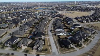 Prosper, Teksas 'taki kıvrımlı yerleşim sokakları çeşitli çatı çizgileri, arka bahçe havuzları, merkezi oyun alanı olan tek aile evlerinin birleşik yerleşim yerlerini oluşturuyor. Ticari binalar, ufukta su kulesi