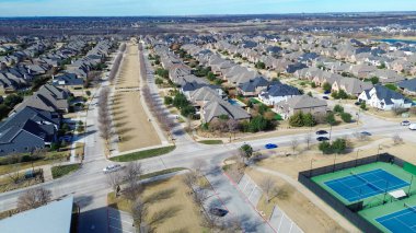 Yapraksız ağaçsız medyan ve iki tenis kortuyla şebeke tarzı yerleşim yeri. Mevsimsel karşıtlık, Prosper, Texas 'ın üst düzey altyapısını ve daha soğuk aylarda imar sürekliliğini vurguluyor. ABD