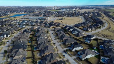 Prosper, Teksas 'ta çocuk parkı olan ilkokul, iki katlı tek katlı evler peyzajlı ön bahçeli, tutarlı mimari ritmi olan temiz ve düzenli konut koridorlarını gösteriyor. ABD