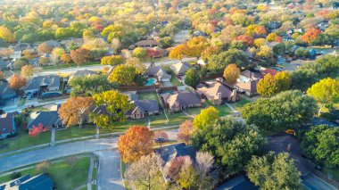 Birçok ev boyunca paralel yerleşim caddelerinde sonbahar renkli ağaçlarla çerçevelenmiş yüzme havuzları ve teraslar yer alıyor. Ahşap çitleri olan lüks banliyö evleri Coppell, Dallas, TX 'te garaj yolları var. ABD