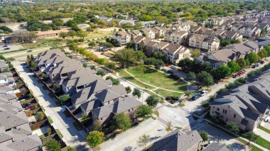 Kasaba evleri ve apartmanlar Gerault Yolu yakınlarındaki bir parkı çevreleyen yürüyüş yolları ve ağaçlarla çevrili. Asfalt çatılar ve çimenli dokular ortak çekirdeği tanımlar, Çiçek Tepesi, Teksas. ABD