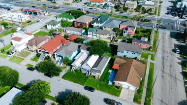 Peyzajlı medyanlar ve döner kavşaklı ana yollar sahil otelleri Stewart Beach 'e doğru giden yerleşim alanlarını kesiyor. Karışık çatı paletleri, park edilmiş arabalar, palmiye ağacı kıyı ritmi, Galveston, Teksas. ABD