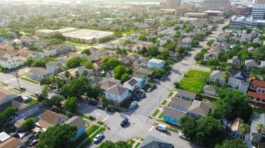 Seawall Bulvarı 'nın yakınında Galveston sağlık bölgesine doğru sıkışık evler ve alçak binalar. Bej kaplama, eğimli çatılar, ağaçlarla kaplı caddeler, ufuk çizgilerine geçiş, Teksas. ABD