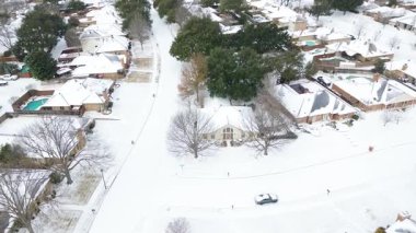 Northlake Woodlands 'daki Mockingbird Lane ve Falcon Lane yakınlarındaki evler karla kaplı çatılar, garaj yolları, yapraksız ağaçlar gösteriyor. Havuzlar, çitler Kış Fırtınası Fern, Coppell, TX