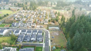 Yeni yerleşik mahallede inşaat evlerinin altında, Meridian Gölü 'ne doğru giden yerel bağlantı yolunun yakınındaki East Hill orman sınırı boyunca oyun alanı var. Kenar mahalle ormanlık arayüzü, Kent, WA. ABD