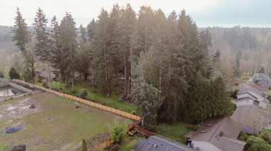 Meridian Rd koridoru boyunca, doğu tepesi ve Maple Vadisi 'ne doğru uzanan yerleşim alanlarının yakınlarındaki büyük boş çitli park alanı. Yeni inşaat alanı, yemyeşil paraşütler, yumuşak ışık, Kent, WA. ABD