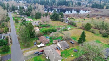 Panther Gölü yakınlarındaki East Hill civarındaki dağılmış göl kenarları dağınık barakalara, garaj yollarına, açık çimlere doğru uzanıyor. Nemli kiremitler, çıplak dallar, bastırılmış mevsimsel ton Kent, WA 'ya yerleşir. ABD