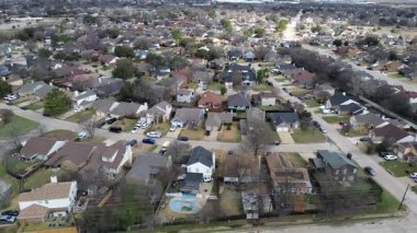 Cravens Park ve Fish Creek Linear Park yakınlarındaki yoğun Güney Arlington banliyö blokları sıkı bir yerleşim alanı oluşturur. Karışık kiremitler, çıplak ağaçlar, sessiz çimenler, Arlington, Teksas 'ta yumuşak kış ışığı.