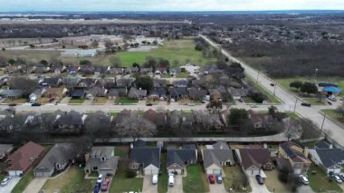 Cravens Park 'ı çevreleyen evler sakin mahalle caddeleri hizasında. Tamirat varyasyonları, kış yeşillikleri, garaj yolu araçları, sessiz ışıklandırma yerleşik banliyö ritmini ortaya çıkardı, Arlington, TX