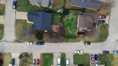 Cravens Park 'ın güneydoğusundaki evler arka bahçelerinde görünen nazik sokak kıvrımlarını takip ediyor. Karışık çatı, soluk çimenler, yapraksız ağaçlar, yumuşak kış ışıkları, DFW mahallesi, Arlington, TX. ABD