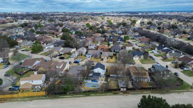 Cravens Park koridorunun güneyindeki yerleşim yerlerinde sıkı konut desenleri ve çitli bahçeler görülüyor. Zıtlıklar, hareketsiz çimenler, dağınık yeşiller, Arlington, Teksas 'ta hafif gri ışıklandırma. ABD