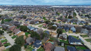 Cravens Park 'ın kuzeyindeki bloklar uzak ticari bölgelere kadar uzanıyor. Değişik kiremitler, yapraksız gölgeler, garaj yolu desenleri, yumuşak gri ışıklı banliyö dokusu, Arlington, TX. ABD