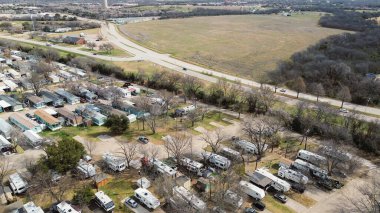 Karavan evleri K Bulvarı 'nın doğusunda TimberCreek Evleri' ne doğru uzanan açık araziye yakın Split Trail Yolu 'nun yanında yer alır. Tarafsız kaplama, hareketsiz çimenler, yapraksız tepe örtüleri, Plano, Teksas 'ta kış manzarası. ABD