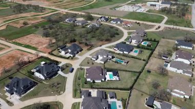 Çiçek Tepesi toplumundan Wellington yakınlarındaki karma kalkınma bölgesi aktif inşaat paketlerinin yanında havuzlu tamamlanmış evler gösteriyor. Toprak tonlu çatılar, Teksas