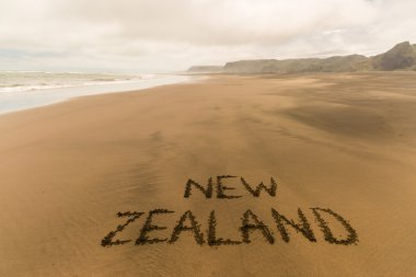 New Zealand written on sandy beach clipart