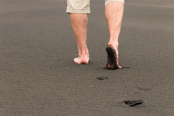 Man blootsvoets lopen op vulkanisch zand — Stockfoto