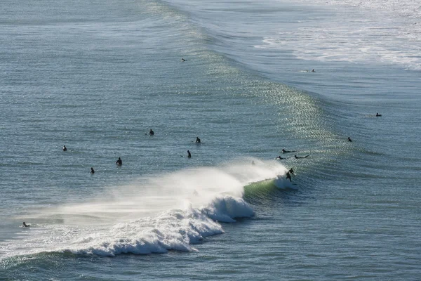 Surfer reiten auf der Welle am Piha-Strand — Stockfoto