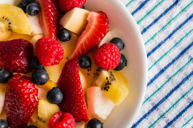 Masa örtüsü üzerinde beyaz kase meyve salatası