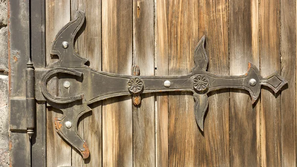 Gothic wrought iron elements on the wooden plank gate — Stock Photo, Image