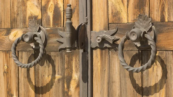 Gothic wrought iron elements on the wooden plank gate — Stock Photo, Image