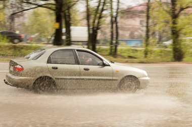 su sıçramalarına altından geçen araba ile tekerlekleri 