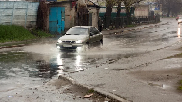 Salpicaduras de debajo de las ruedas de un coche que pasa a través de — Foto de Stock