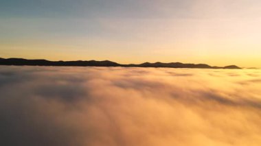 Alçak bulutların üzerinde gün doğumu. Harika sabah manzarası.