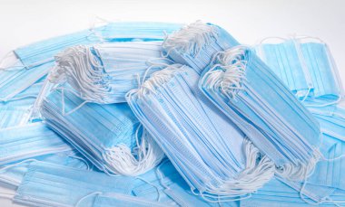 Birçok tıbbi tek kullanımlık maske, beyaz bir arka plan maskesinde 19 coronavirüs veya PM2.5 toz parçacıklarına karşı koruma için iki deste.