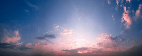 Sabah mavi gökyüzünün manzarası, turuncu ve kırmızı güneş ışığıyla aydınlanıyor, renkli şafakla..