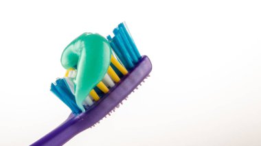 Beyaz arkaplanda diş fırçasında diş macunu.
