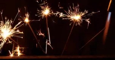 Siyah arka planda yanan üç kıvılcım.