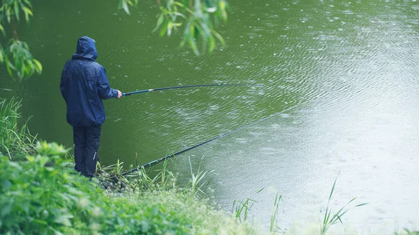 Pescatore Pesca Nel Lago Con Una Canna Pesca Sotto Pioggia — Foto Stock