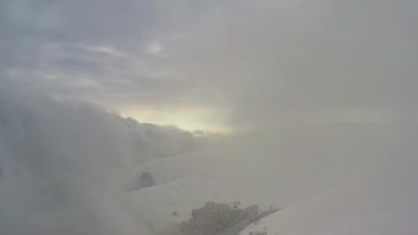 Sneeuwstorm en wolken boven op de berg. Luchtzicht. — Stockvideo