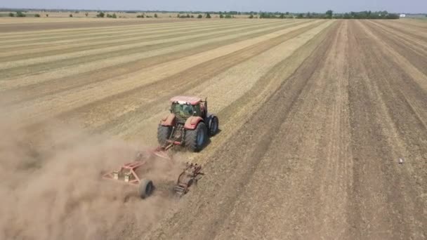 Γεωργικές εργασίες με τρακτέρ. Ο οδηγός τρακτέρ παίζει το έδαφος με ένα δίσκο harrow. — Αρχείο Βίντεο